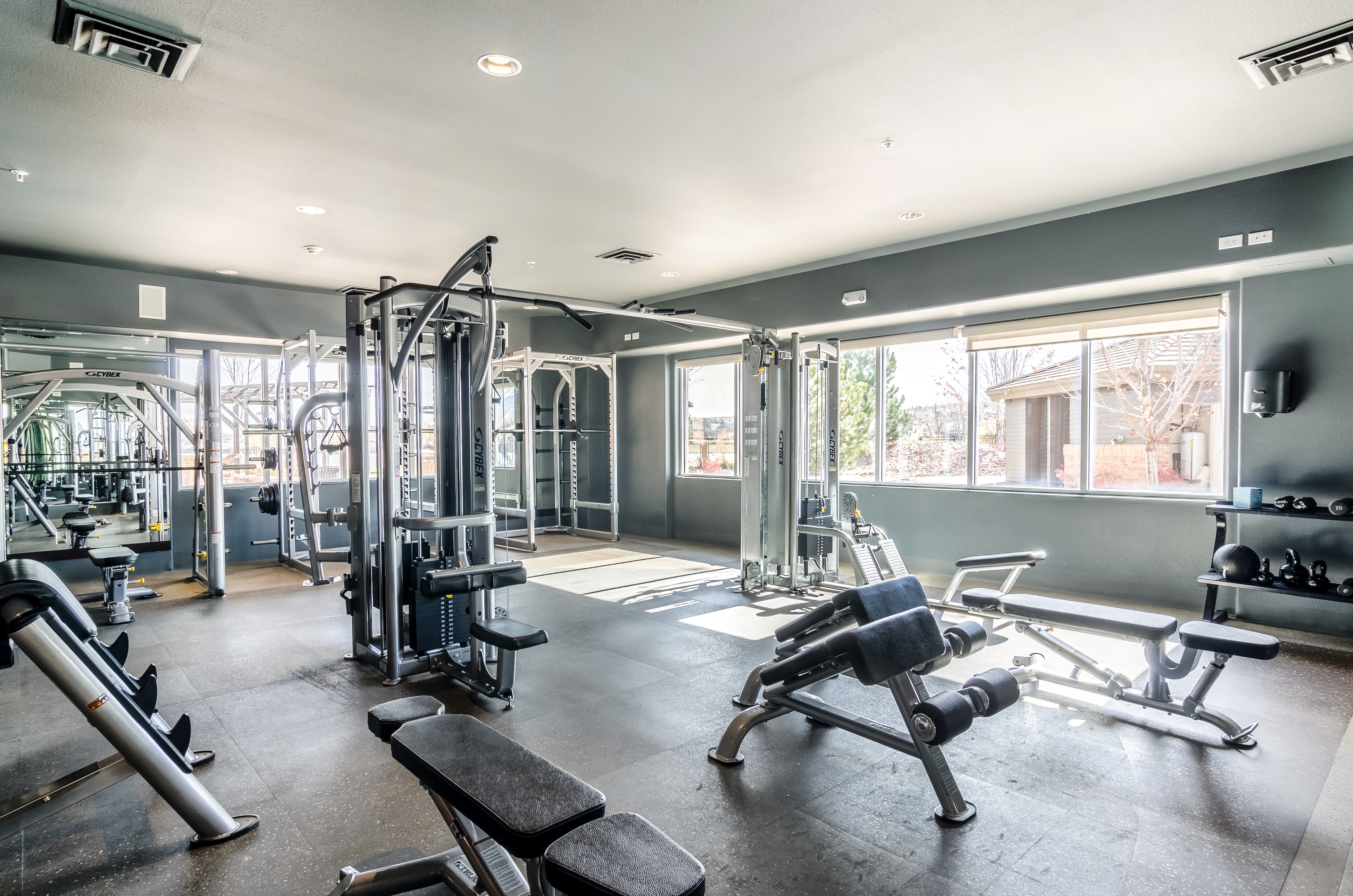 A spacious gym with a variety of equipment including a leg press machine.